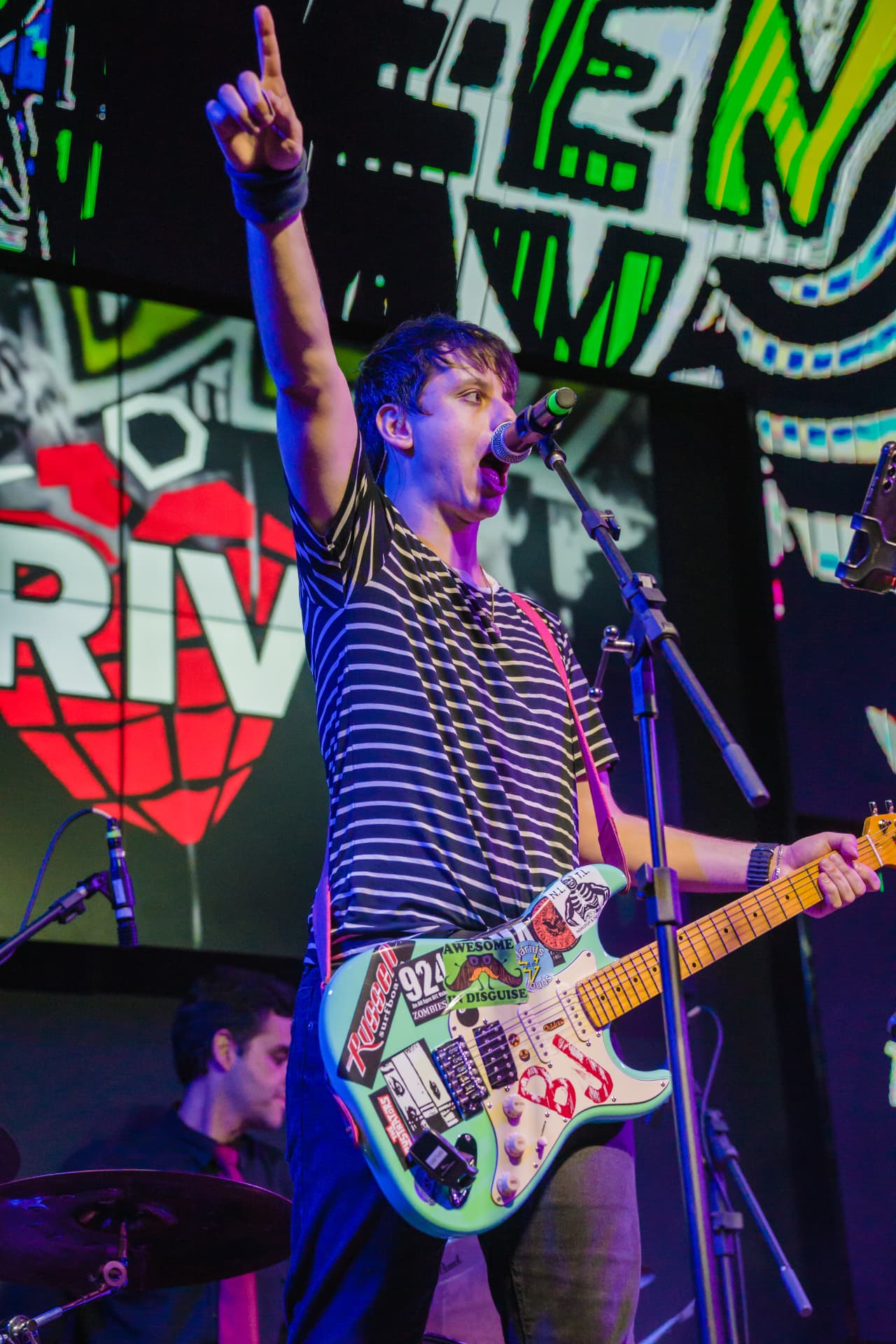 Vocalista da Drive com guitarra coberta de adesivos punk