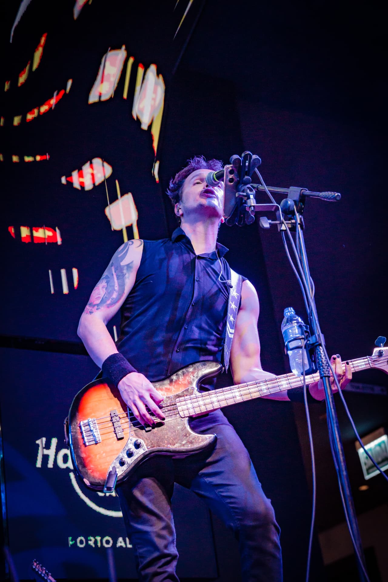Baixista da Drive cantando ao microfone em contraluz